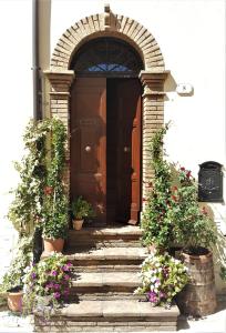 an entrance to a house with a wooden door and flowers at La Casa nel Borgo in Torre Orsina