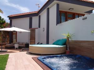 a backyard with a hot tub in front of a house at Villa Beatriz in Salobre