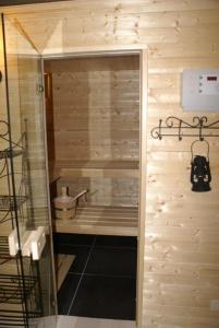 a bathroom with a walk in shower next to a wooden wall at Holiday home Brokantie in Pamel