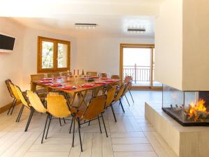 comedor con mesa, sillas y chimenea en Luxury chalet near the ski slopes en Arc 1600