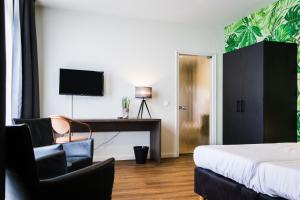 a bedroom with a bed and a desk and a tv at Het Montferland in Zeddam