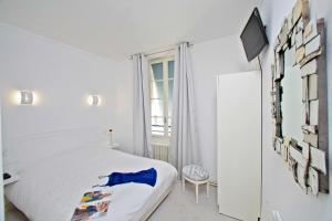 a white bedroom with a bed and a window at Hôtel Le Coin des Halles in Cahors