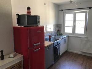 a kitchen with a red refrigerator with a tv on top at Ferienwohnung Haltingen in Weil am Rhein