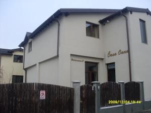 a white house with a wooden fence in front of it at Casa Oana in Iaşi