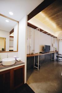 a bathroom with a sink and a large mirror at Laekhon Nonbai in Nakhon Si Thammarat
