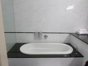 a sink in a bathroom with a glass wall at The Links Guest House in Pretoria