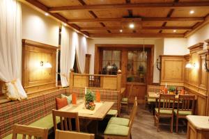 ein Restaurant mit Holztischen und -stühlen in einem Zimmer in der Unterkunft Gasthof Großschedl zum Kramerwirt in Lassnitzhöhe
