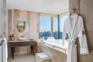 a bathroom with a tub and a sink and a mirror at Pan Pacific Yangon in Yangon