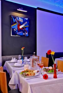 une salle à manger avec deux tables et des assiettes de nourriture dans l'établissement Hôtel Le Coin des Halles, à Cahors