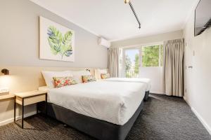 een slaapkamer met een groot bed en een raam bij Nightcap at Findon Hotel in Adelaide