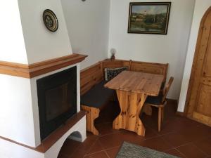 a dining room with a wooden table and a fireplace at Terézia Vendégház in Tihany