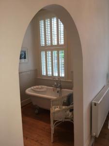 a bathroom with a bath tub and a window at Raymonds in Douglas