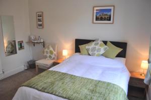 Un dormitorio con una gran cama blanca con dos lámparas. en Woodlands 159, en Pershore