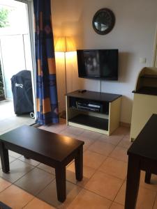 a living room with a tv and a coffee table at Résidence les jardins du phoebus appartement in Gruissan