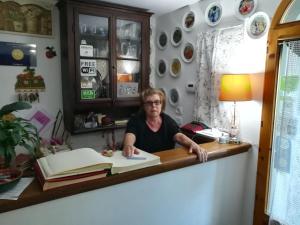 a woman sitting at a desk with a book at B&B Il Ghiro in Pracchia