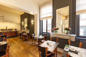 a restaurant with tables and chairs and a counter at Hotel Loreto in Bruges