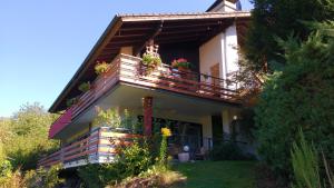 una casa con un balcón con macetas. en Ferienwohnung Rhododendron - Natur pur Kinderparadies, en Rotenburg an der Fulda