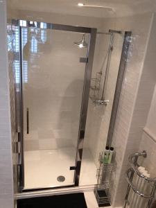 a shower with a glass door in a bathroom at Raymonds in Douglas
