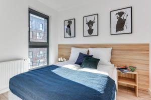 a bedroom with a blue and white bed and a window at Browar Gdanski Budget by Renters in Gdańsk