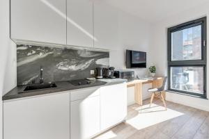 a white kitchen with a sink and a desk at Browar Gdanski Budget by Renters in Gdańsk