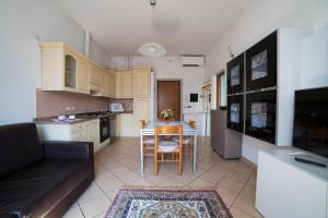 a kitchen and living room with a table and a couch at Vicino al mare in centro sulla nuova pista ciclabile in Imperia