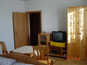 - un salon avec une télévision et une armoire en bois dans l'établissement Harzer Ferienpension, à Timmenrode