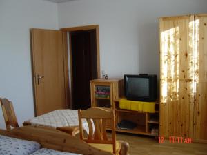 a living room with a tv and a wooden cabinet at Harzer Ferienpension in Timmenrode