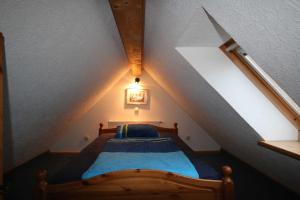 een slaapkamer met een houten bed op zolder bij Ferienwohnung Schauf in Gelting