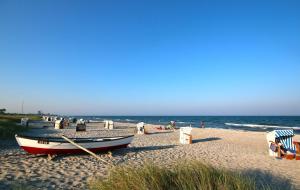 een boot op een strand met de oceaan op de achtergrond bij Ferienwohnung Schauf in Gelting