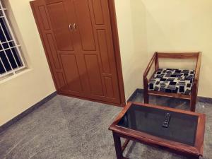 a room with a door and a table and a chair at Hotel Wins in Kanyakumari