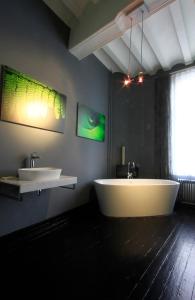 un bagno con due lavandini e una grande vasca di Bed & breakfast in monumental house maastricht centre a Maastricht Altre 32 foto