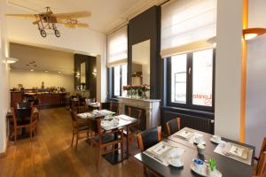 a restaurant with tables and chairs and a bar at Hotel Loreto in Bruges