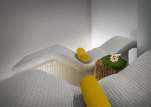 a room with a bed and a yellow chair at Hotel Jardín Tecina in Playa de Santiago