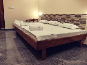 a large bed with white sheets and pillows on it at Hotel Wins in Kanyakumari