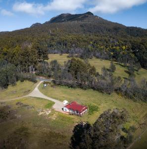 an aerial view of a farm with a red barn at Mountain Blue Guest House in Deloraine