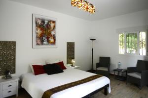 sypialnia z białym łóżkiem i krzesłem w obiekcie Cortijo Oro Verde B&B w mieście Tabernas +55 zdjęć