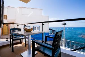 a dining room with a balcony overlooking the ocean at Apartments La Caleta Sunrises in Adeje