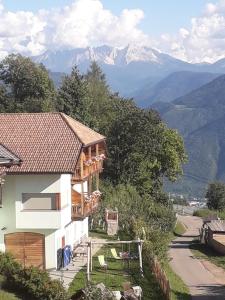a house on a hill with mountains in the background at Roanerhof in San Genesio Atesino