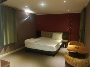 Sunshine Motel في بوسان: غرفة نوم صغيرة بها سرير وكرسي