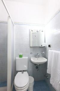 a white bathroom with a toilet and a sink at Albergo Al Carugio in Monterosso al Mare