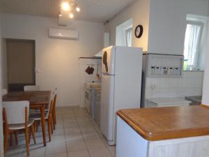Il comprend une cuisine équipée d'un réfrigérateur blanc et d'une table. dans l'établissement 34 Rue de la Coucouroune Gîte de la Coucouroune, à Soual