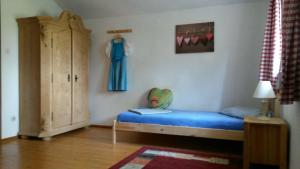 a bedroom with a bed and a dresser in a room at Ferienhaus Westerbuchberg in Übersee