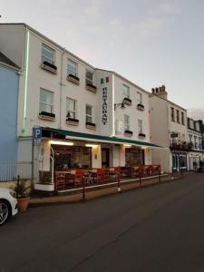 a building with a restaurant on the side of a street at Bon Viveur Guest House in Saint Aubin