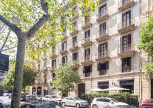 a large white building with cars parked in front of it at Casp Green House in Barcelona