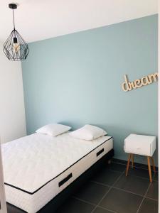 1 dormitorio con cama blanca y pared azul en Appt moderne Vieil Antibes 3 pièc, en Antibes