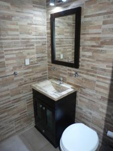 a bathroom with a sink and a toilet and a mirror at Esmeralda y Tucumán in Buenos Aires