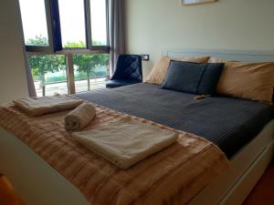 een groot bed met twee handdoeken erop bij Residencial Playa Poniente in Gijón