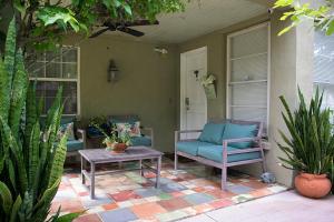 a porch with two chairs and a table and a door at Winter Park charm in Orlando