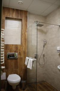 a bathroom with a toilet and a glass shower at Hotel Calisia in Kalisz