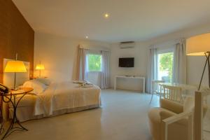 a bedroom with a bed and a living room at Amazonia Estoril Hotel in Estoril